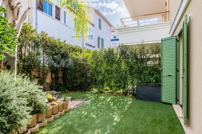 a garden with grass and plants in a building at Palm Beach - swimming pool - beach at few steps in Cannes