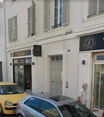 a man standing outside of a building with cars parked outside at SMART STUDIO in Cannes