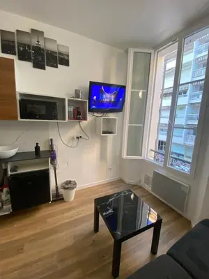 a living room with a coffee table and a flat screen tv at SMART STUDIO in Cannes