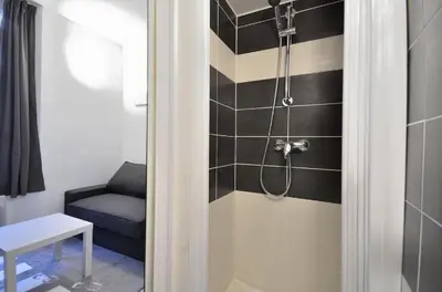 a bathroom with a shower with a bench and a chair at SMART STUDIO in Cannes