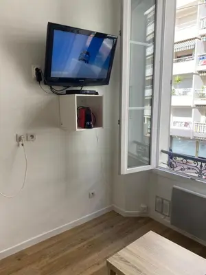 a flat screen tv on a wall next to a window at SMART STUDIO in Cannes