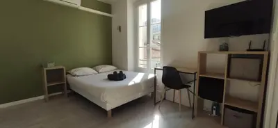 a bedroom with a bed and a flat screen tv at APPARTEMENT CANNES MONTFLEURY in Cannes