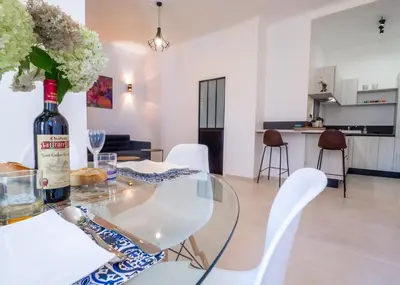 a bottle of wine on a glass table in a living room at Grand appartement 4 pièces centre de Cannes in Cannes