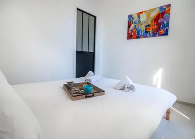 a white room with a bed with a tray on it at Grand appartement 4 pièces centre de Cannes in Cannes
