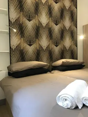 a bed with two pillows and a wall at Appartement Suquet Forville in Cannes