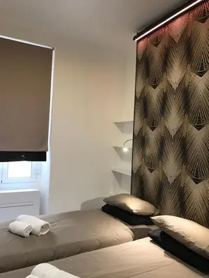 a bedroom with two beds and a wall with a screen at Appartement Suquet Forville in Cannes