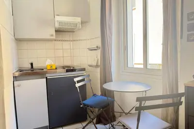 a small kitchen with a sink and a table at 1-bedroom apt 5 minutes from the Congress Center in Cannes