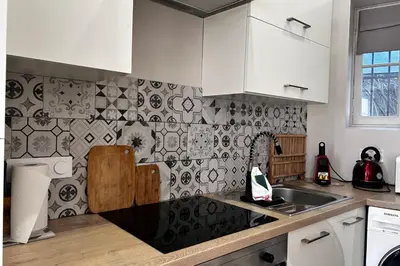 a kitchen with a sink and a tile wall at 1-bedroom apt 5 minutes from the Congress Center in Cannes