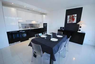 a dining room with a black table and chairs at T3 Pte Croisette Vue mer Plage à 100m in Cannes