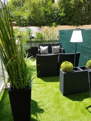 a garden with black furniture and plants on the grass at Studio Center Cannes grande Terasse in Cannes