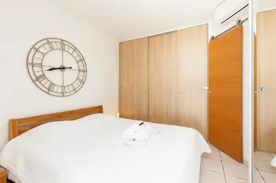 a bedroom with a bed and a clock on the wall at Résidence Saint Rémy 2 in Cannes