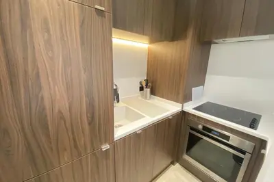 a small kitchen with wooden cabinets and a stove at Renovated 2 bedrooms - Boulevard de la Croisette in Cannes