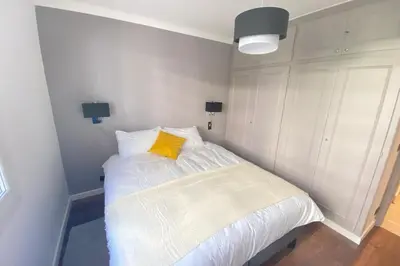 a bedroom with a white bed with a yellow pillow at Renovated 2 bedrooms - Boulevard de la Croisette in Cannes