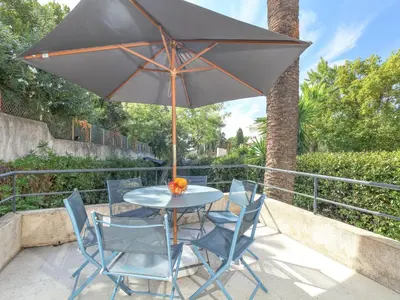 a table and chairs with an umbrella on a patio at Holiday Home Villa Esmeralda by Interhome in Cannes