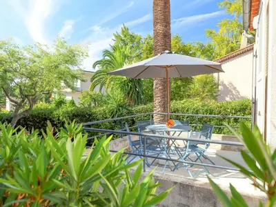 a patio with a table and an umbrella at Holiday Home Villa Esmeralda by Interhome in Cannes