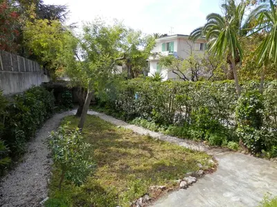 a garden with a tree and a fence at Holiday Home Villa Esmeralda by Interhome in Cannes