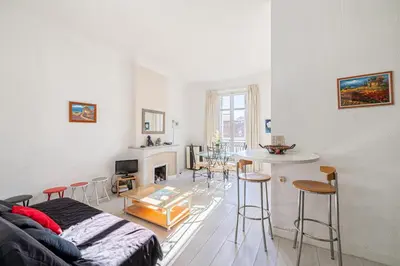 a living room with a couch and a table at L'ESCAPADE CITADINE avec 2 chambres, proche de la Croisette, des plages et du Palais in Cannes