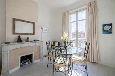 a dining room with a table and a fireplace at L'ESCAPADE CITADINE avec 2 chambres, proche de la Croisette, des plages et du Palais in Cannes