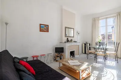 a living room with a couch and a fireplace at L'ESCAPADE CITADINE avec 2 chambres, proche de la Croisette, des plages et du Palais in Cannes