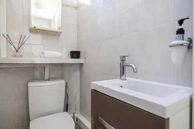 a white bathroom with a sink and a toilet at L'ESCAPADE CITADINE avec 2 chambres, proche de la Croisette, des plages et du Palais in Cannes