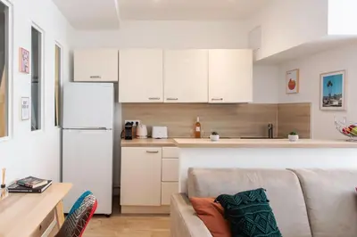 a living room with a couch and a kitchen at C11 - 1 BDR Rue Meynadier 5min Palais Festivals & Sea - AC in Cannes
