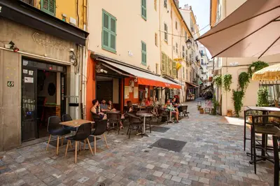 a street with tables and chairs and people sitting at tables at C11 - 1 BDR Rue Meynadier 5min Palais Festivals & Sea - AC in Cannes