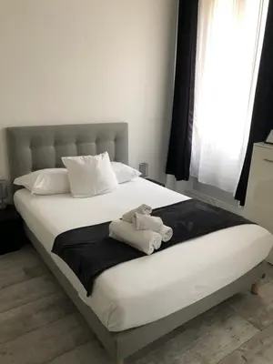 a bed with a teddy bear sitting on a blanket at Studios des Congrès et Festivals in Cannes