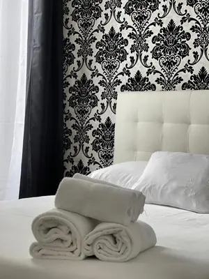 a bed with a towel on it with a wallpaper at Studios des Congrès et Festivals in Cannes