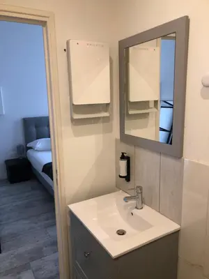 a bathroom with a sink and a mirror and a bed at Studios des Congrès et Festivals in Cannes