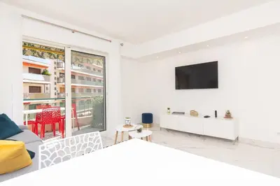 a white living room with a tv on a wall at Brand new 2 bedrooms next to Croisette ! in Cannes