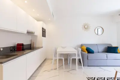 a kitchen and a living room with a couch and a table at Brand new 2 bedrooms next to Croisette ! in Cannes