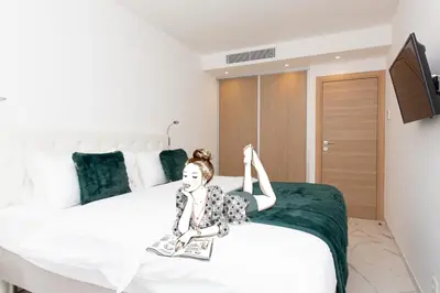 a woman laying on a bed with her leg in the air at Brand new 2 bedrooms next to Croisette ! in Cannes