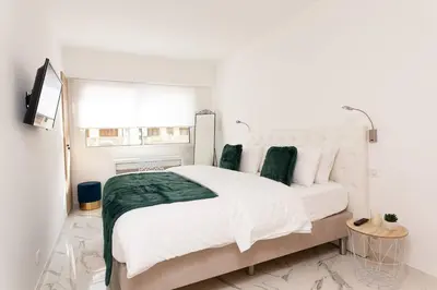 a white bedroom with a large bed and a window at Brand new 2 bedrooms next to Croisette ! in Cannes