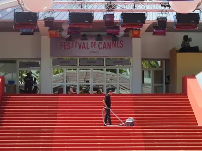 a man walking down the red stairs with a dog at Appartement Cannes à quelques pas de la mer, de la Croisette et du Palais des Festivals in Cannes