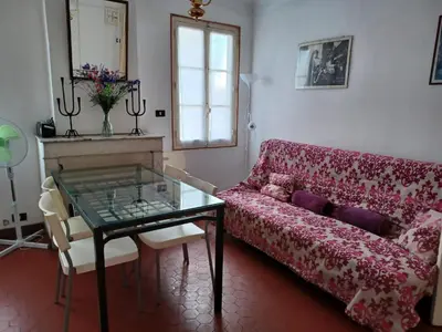 a living room with a red couch and a glass table at Appartement Cannes à quelques pas de la mer, de la Croisette et du Palais des Festivals in Cannes
