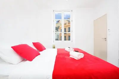 a bedroom with a red and white bed with red pillows at Astoux YourHostHelper in Cannes