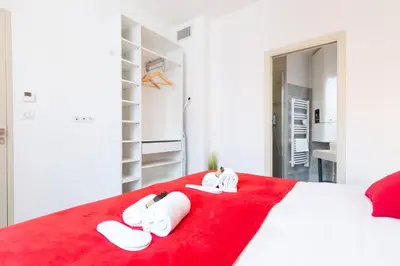 a bedroom with a red bed with slippers on it at Astoux YourHostHelper in Cannes