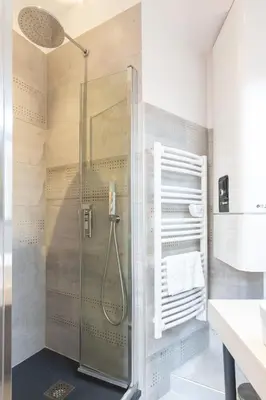 a shower with a glass door in a bathroom at Astoux YourHostHelper in Cannes