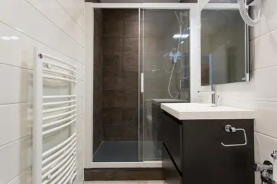 a bathroom with a shower with a sink and a mirror at COTE PORT in Cannes