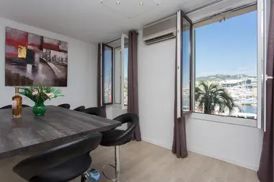 a dining room with a table and a large window at COTE PORT in Cannes