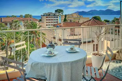 a table on a balcony with a view of a city at IMMOGROOM - Close beaches- Beautiful terrace - Seaview - CONGRESSBEACHES in Cannes