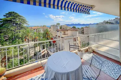 a balcony with a table and a view of a city at IMMOGROOM - Close beaches- Beautiful terrace - Seaview - CONGRESSBEACHES in Cannes