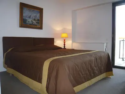a bedroom with a bed and a lamp and a window at Appartement Relais de la Reine Cannes Croisette in Cannes
