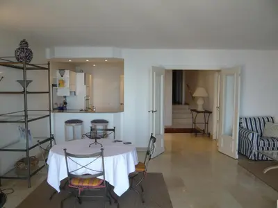 a dining room with a white table and chairs at Appartement Relais de la Reine Cannes Croisette in Cannes