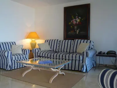 a living room with two couches and a coffee table at Appartement Relais de la Reine Cannes Croisette in Cannes