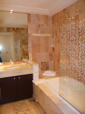 a bathroom with a shower and a sink and a tub at Appartement Relais de la Reine Cannes Croisette in Cannes