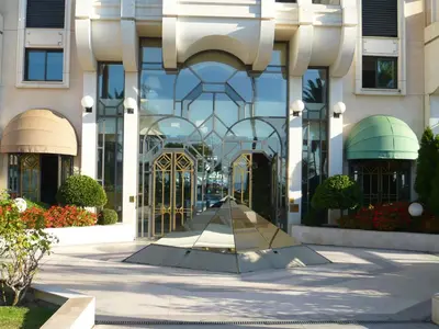 a building with a gate in the middle of a sidewalk at Appartement Relais de la Reine Cannes Croisette in Cannes