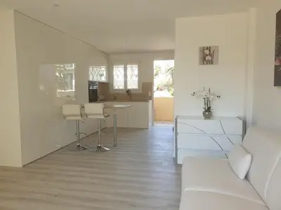 a living room with a couch and a table at STUDIO LES ALGUES in Cannes