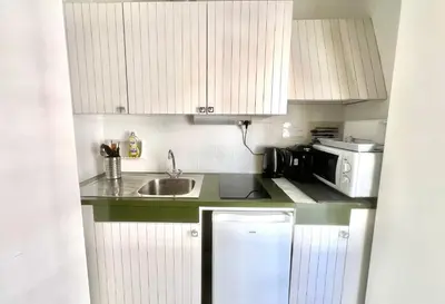 a small kitchen with white cabinets and a sink at Branly 3, by Welcome to Cannes in Cannes