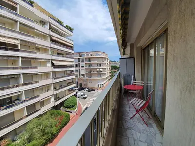 a bedroom with a bed and a table and a kitchen at Branly 3, by Welcome to Cannes in Cannes